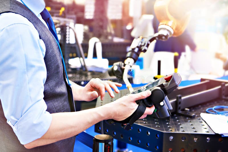 Operator controls a robotic welding machine at an exhibition. Controls automation stock images, royalty-free photos and pictures
