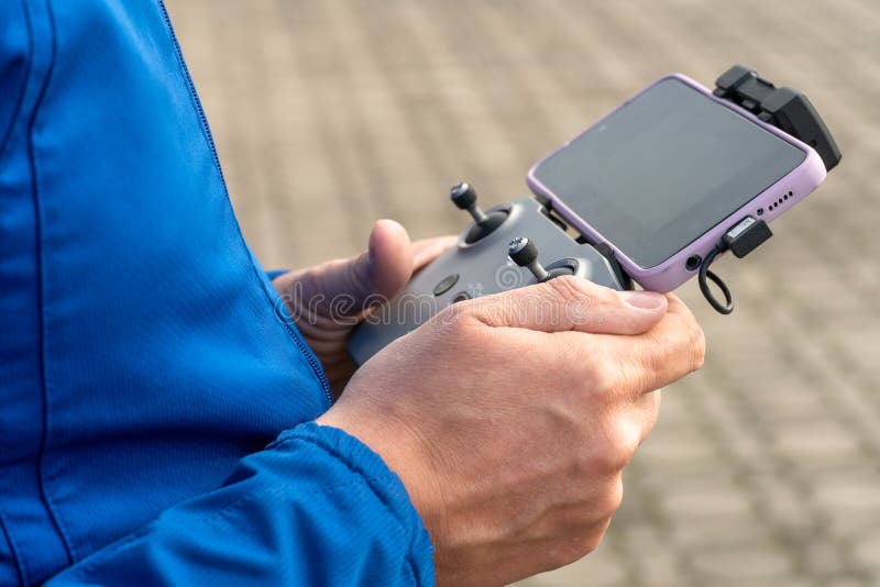 The Operator Holds the Remote Control of the Drone in His Hands. a