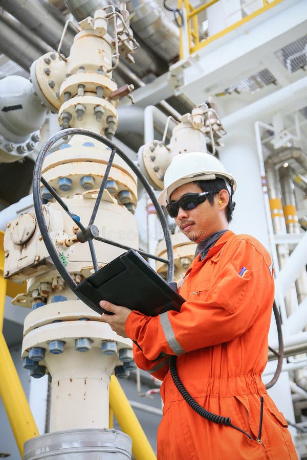 Operator recording operation of oil and gas process at oil and rig plant, offshore oil and gas industry, offshore oil and rig stock photography Operator recording operation of oil and gas process at oil and rig plant, offshore oil and gas industry, offshore oil and rig stock photography