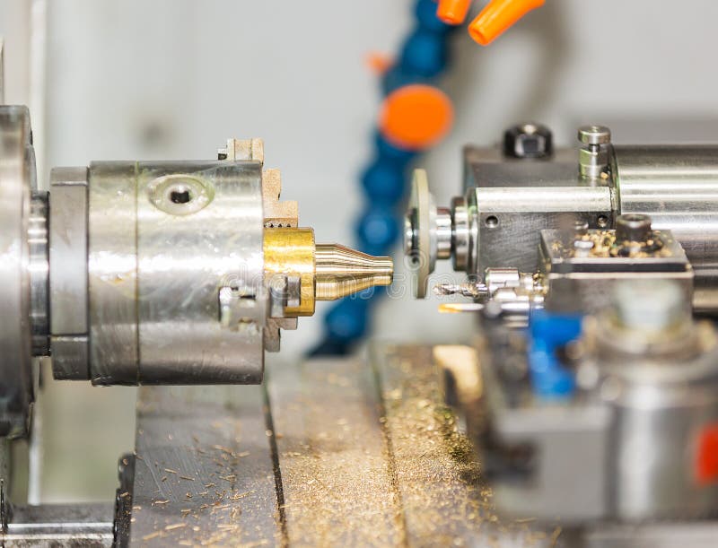 Operator turning and grinding brass autopart by cnc lathe stock photography