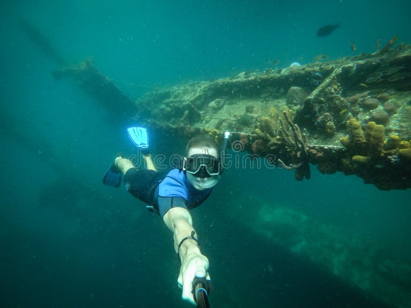 Operatore subacqueo libero che prende selfie con la nave incavata su fondo fotografia stock libera da diritti Operatore subacqueo libero che prende selfie con la nave incavata su fondo fotografia stock libera da diritti