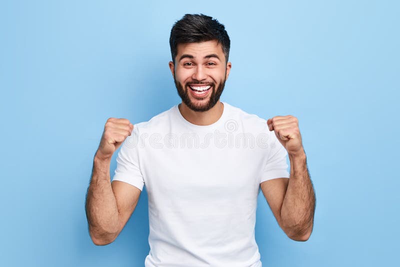 Opgewekt jong Arabisch mens het vieren succes, overwinning stock afbeeldingen Opgewekt jong Arabisch mens het vieren succes, overwinning stock afbeeldingen