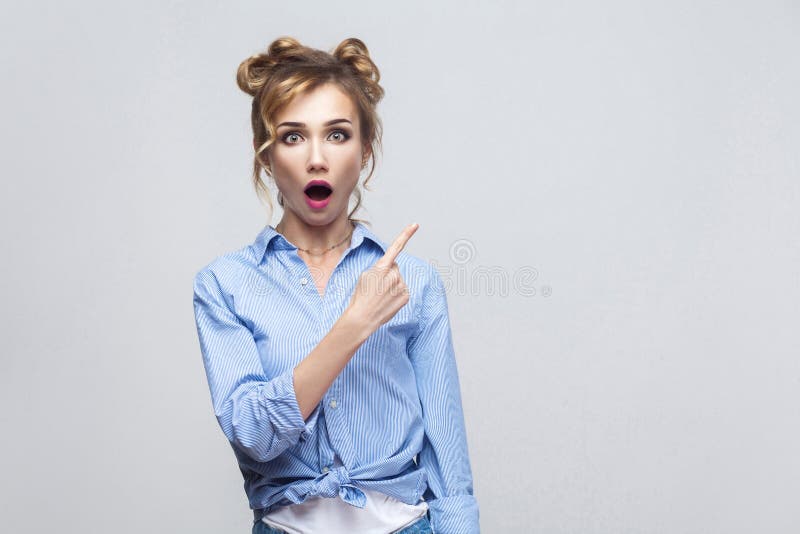 Opgewekte blondevrouw die vinger richten die zijdelings, wenkbrauwen opheffen stock foto's Opgewekte blondevrouw die vinger richten die zijdelings, wenkbrauwen opheffen stock foto's