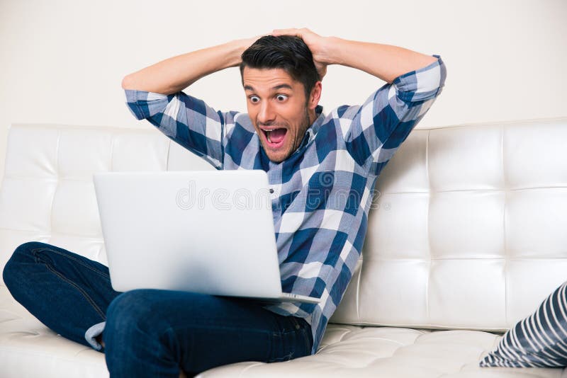 Opgewekte mens die spel op laptop kijken royalty-vrije stock foto's Opgewekte mens die spel op laptop kijken royalty-vrije stock foto's