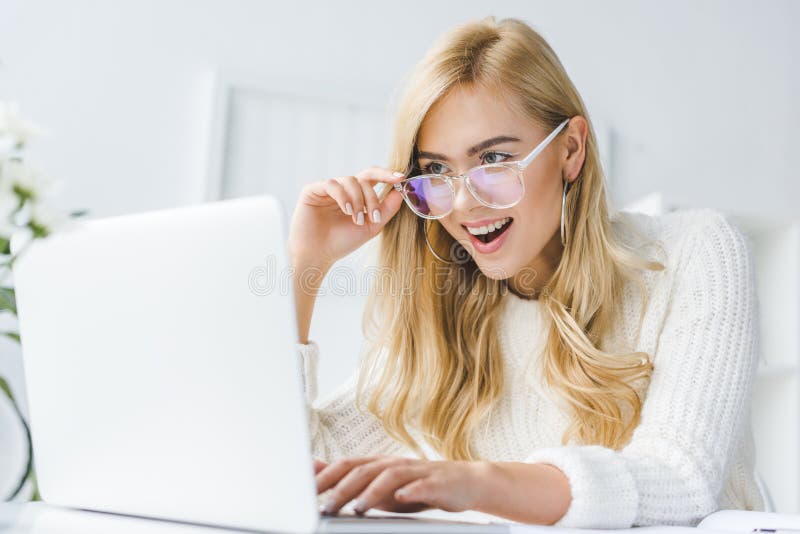 opgewekte modieuze onderneemster in oogglazen die laptop in modern licht met behulp van stock foto's opgewekte modieuze onderneemster in oogglazen die laptop in modern licht met behulp van stock foto's