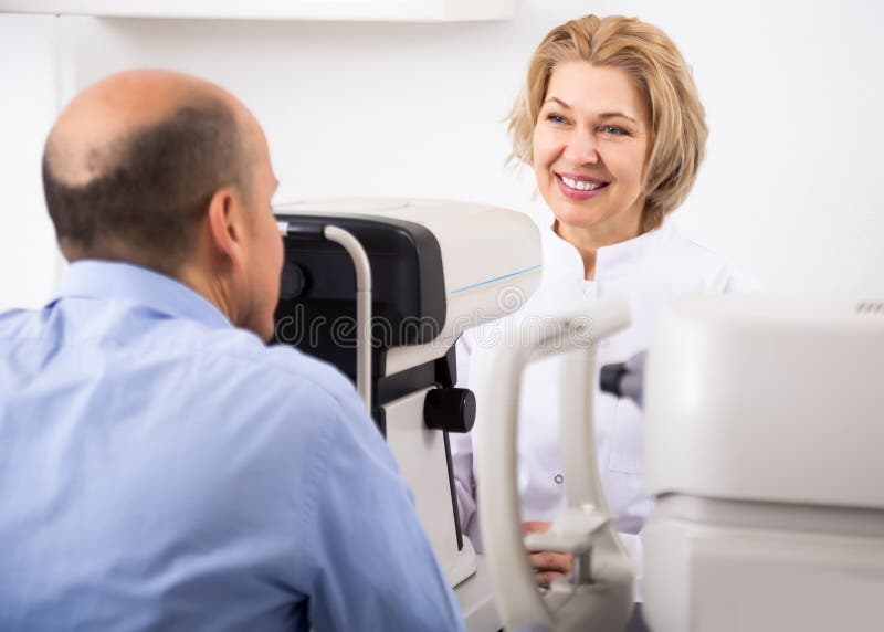 Ophthalmologist and male pensioner checking eyesight royalty free stock image Ophthalmologist and male pensioner checking eyesight royalty free stock image