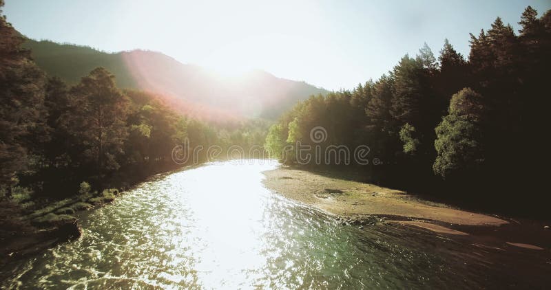 opinião aérea de 4k UHD Baixo voo sobre o rio frio fresco da montanha na manhã ensolarada do verão