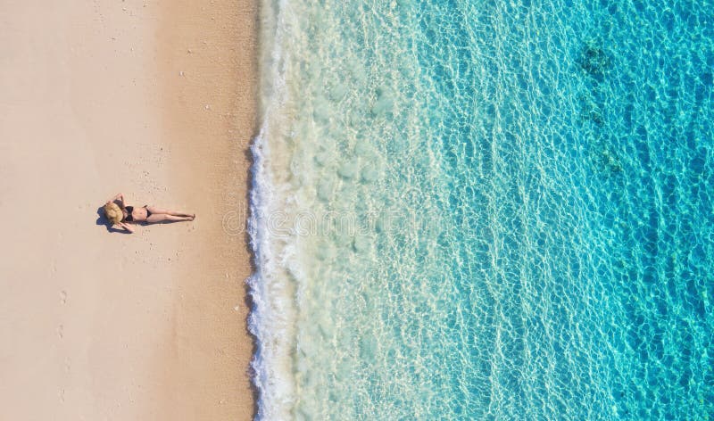 Opinião aérea uma menina na praia em Bali, Indonésia F?rias e aventura ?gua da praia e da turquesa Vista superior do zangão em b