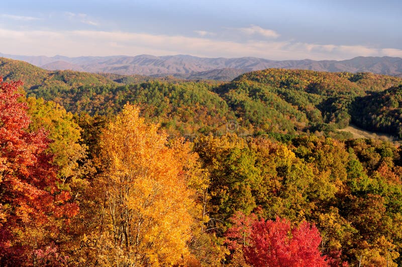 Opinião da via pública larga e urbanizada dos montes em montanhas fumarentos em Autumn Color