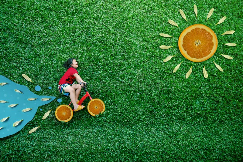 Opinião de ângulo alto do crianças asiáticas felizes A menina na bicicleta estabelece no gramado verde no verão Sunny Day Imagina