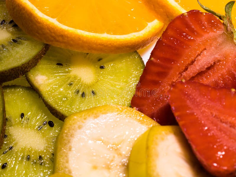 Opinião do close-up em frutos tropicais: banana, quivi, laranja, e morangos imagem de stock royalty free Opinião do close-up em frutos tropicais: banana, quivi, laranja, e morangos imagem de stock royalty free