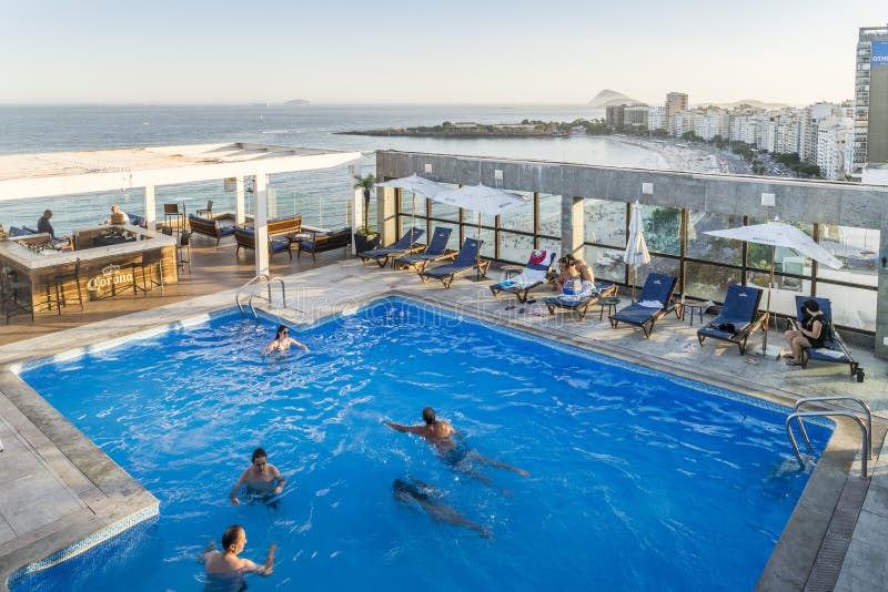 A opinião do telhado os nadadores em uma associação luxuoso da sótão de luxo do hotel e a barra que negligencia Copacabana encalh fotos de stock royalty free A opinião do telhado os nadadores em uma associação luxuoso da sótão de luxo do hotel e a barra que negligencia Copacabana encalh fotos de stock royalty free