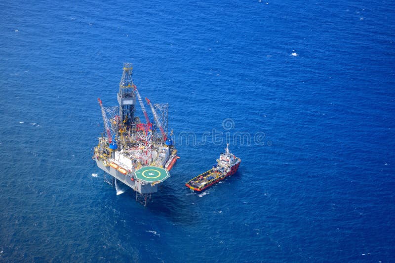 A opinião superior de plataforma petrolífera de perfuração a pouca distância do mar dos aviões. imagens de stock A opinião superior de plataforma petrolífera de perfuração a pouca distância do mar dos aviões. imagens de stock