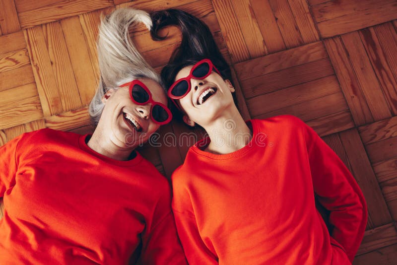 Opinião superior a mãe e a filha que encontram-se no assoalho com togeth das cabeças imagem de stock royalty free Opinião superior a mãe e a filha que encontram-se no assoalho com togeth das cabeças imagem de stock royalty free