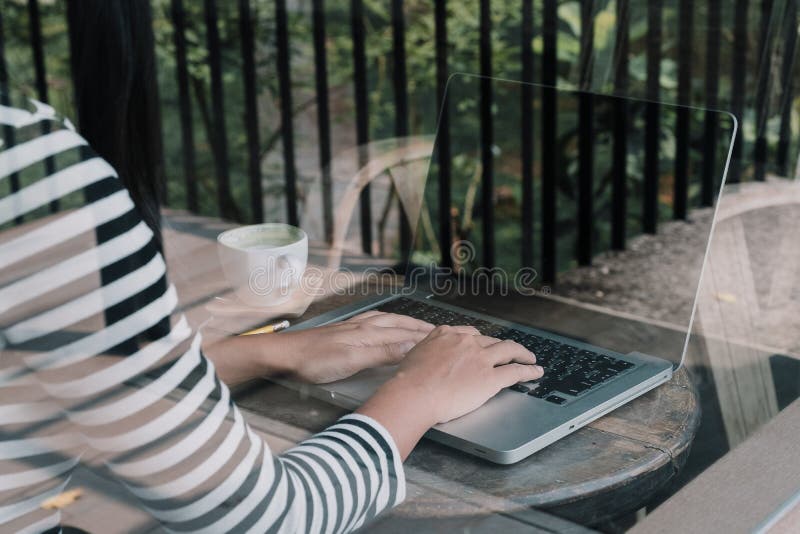 A opinião traseira o freelancer da mulher está trabalhando e entrega o keyboa de datilografia imagem de stock royalty free A opinião traseira o freelancer da mulher está trabalhando e entrega o keyboa de datilografia imagem de stock royalty free