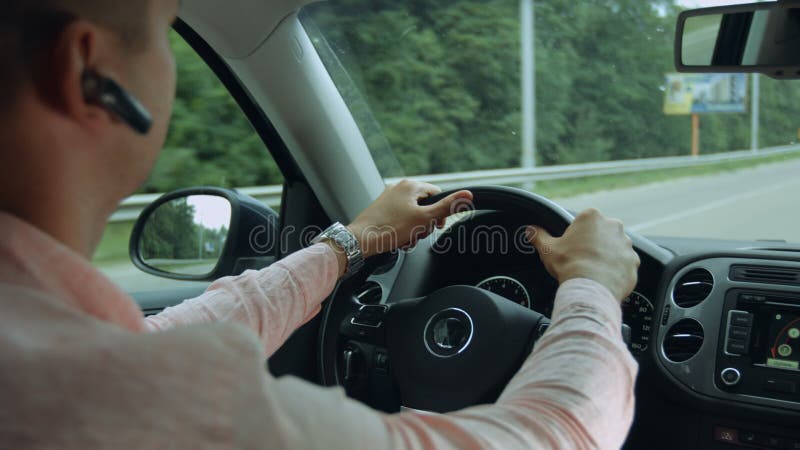 Opinião traseira o homem que conduz o carro na estrada