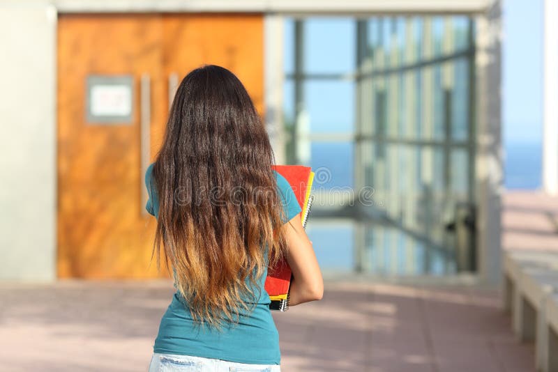 Opinião traseira uma menina adolescente que anda para a escola imagens de stock Opinião traseira uma menina adolescente que anda para a escola imagens de stock