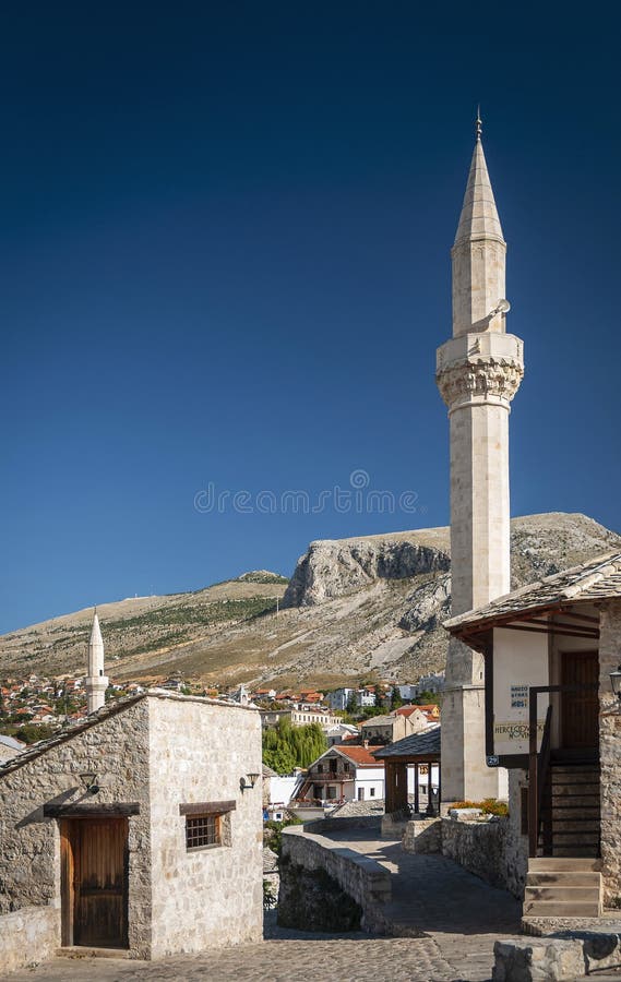Opinião velha de casas e de mesquita de cidade em mostar Bósnia imagens de stock Opinião velha de casas e de mesquita de cidade em mostar Bósnia imagens de stock