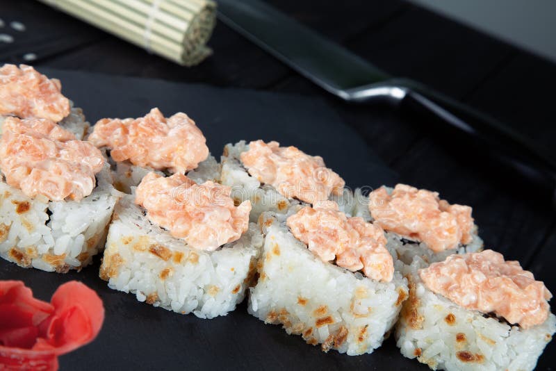 Opinión ascendente cercana sobre los rollos de sushi con con los pescados, el quingombó y el queso rojos de Philadelphia en un ta imágenes de archivo libres de regalías Opinión ascendente cercana sobre los rollos de sushi con con los pescados, el quingombó y el queso rojos de Philadelphia en un ta imágenes de archivo libres de regalías