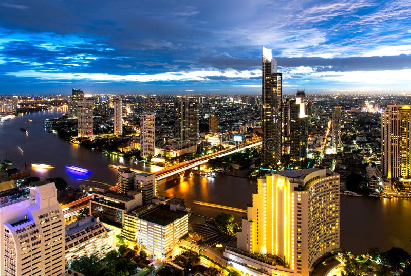 Opinión aérea de la noche sobre el edificio de oficinas moderno de Bangkok en zona del negocio de Bangkok cerca del río con el ci foto de archivo libre de regalías Opinión aérea de la noche sobre el edificio de oficinas moderno de Bangkok en zona del negocio de Bangkok cerca del río con el ci foto de archivo libre de regalías