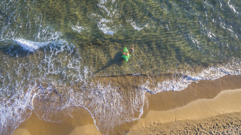 Opinión aérea del abejón los niños que juegan con un inflable en una playa y un mar en Corfú Grecia imagen de archivo libre de regalías Opinión aérea del abejón los niños que juegan con un inflable en una playa y un mar en Corfú Grecia imagen de archivo libre de regalías