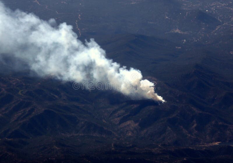 Aerial view of smoke rising from a forest fire in the mountains. Increasing forest fires in the rugged mountain west cause damage to homes and threaten forest health. Aerial view of smoke rising from a forest fire in the mountains. Increasing forest fires in the rugged mountain west cause damage to homes and threaten forest health.