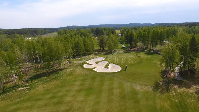 Opinión aérea los golfistas que juegan en putting green Jugadores profesionales en un campo de golf verde fotografía de archivo libre de regalías Opinión aérea los golfistas que juegan en putting green Jugadores profesionales en un campo de golf verde fotografía de archivo libre de regalías