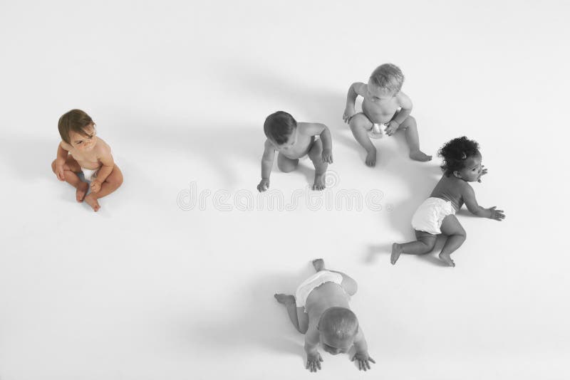 Opinión de alto ángulo el bebé que mira a otros bebés que se arrastran en piso