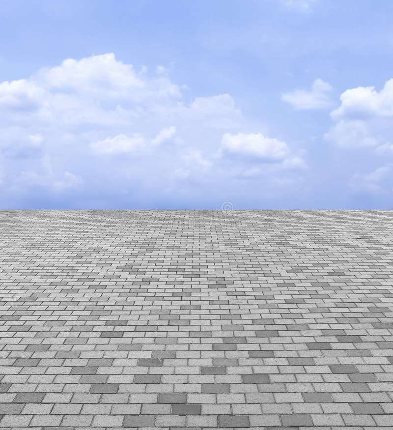 Opinión de perspectiva Gray Brick Stone Street Road monótono Acera, fondo de la textura del pavimento con el cielo azul y nube