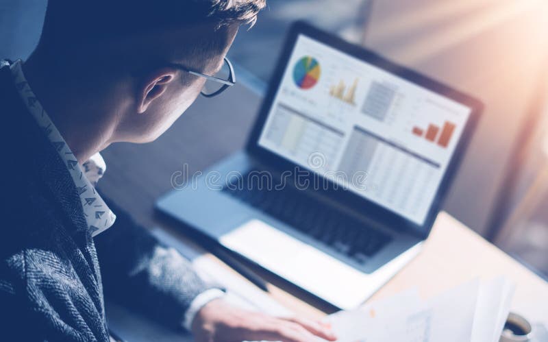 Opinión del primer el analista de mercado de finanzas en las lentes que trabajan en la oficina soleada en el ordenador portátil m foto de archivo Opinión del primer el analista de mercado de finanzas en las lentes que trabajan en la oficina soleada en el ordenador portátil m foto de archivo