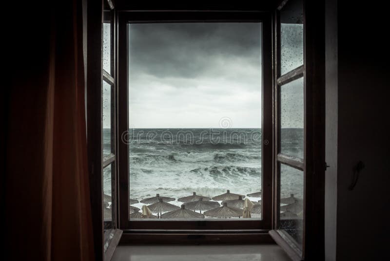 Opinión dramática del mar de la ventana abierta con las ondas tempestuosas grandes y del cielo dramático durante la lluvia y el t fotografía de archivo Opinión dramática del mar de la ventana abierta con las ondas tempestuosas grandes y del cielo dramático durante la lluvia y el t fotografía de archivo