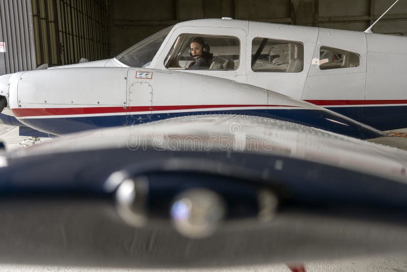 Opini?n exterior el piloto With Headset de los aviones y de la mujer en la carlinga foto de archivo Opini?n exterior el piloto With Headset de los aviones y de la mujer en la carlinga foto de archivo