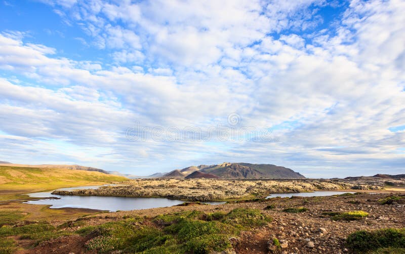 Opinión panorámica del paisaje islandés hermoso del verano con el prado, las cordilleras coloridas, y el cielo hermoso como fondo foto de archivo Opinión panorámica del paisaje islandés hermoso del verano con el prado, las cordilleras coloridas, y el cielo hermoso como fondo foto de archivo