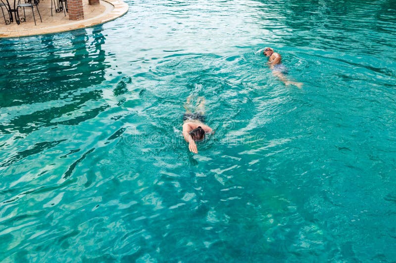 Opinión superior dos hombres caucásicos que nadan arrastre delantero en piscina foto de archivo Opinión superior dos hombres caucásicos que nadan arrastre delantero en piscina foto de archivo