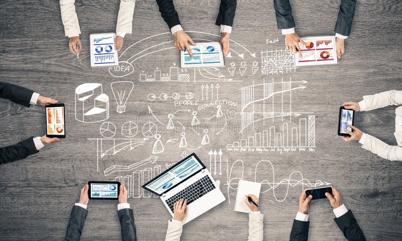 Opinión superior los empresarios que se sientan en la tabla y que usan los artilugios fotos de archivo Opinión superior los empresarios que se sientan en la tabla y que usan los artilugios fotos de archivo
