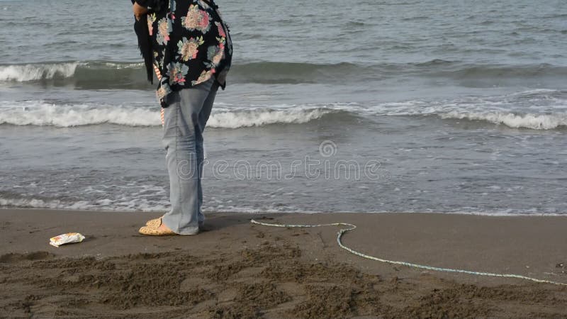 Opinión trasera la madre y el niño joven con el pañal que caminan en la playa almacen de metraje de vídeo