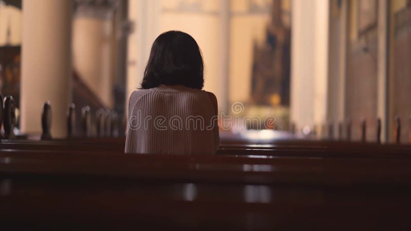Opinión trasera la mujer cristiana que ruega en iglesia almacen de video
