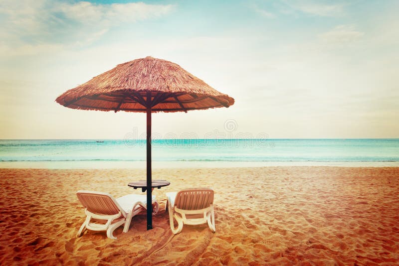 Tropical beach view. Two beach chairs with sun umbrellas. Vacation concept. Tropical beach view. Two beach chairs with sun umbrellas. Vacation concept.