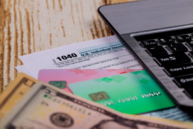 Opodatkowywa Federacyjnych 1040 formularzowych komputerowej klawiatury i amerykanina dolarów obraz stock Opodatkowywa Federacyjnych 1040 formularzowych komputerowej klawiatury i amerykanina dolarów obraz stock