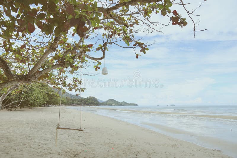 Opróżnia drewnianego huśtawkowego obwieszenie na gałąź w słonecznym dniu blisko plaży koh Chang, zatoka Tajlandia, rocznika filtr obrazy stock Opróżnia drewnianego huśtawkowego obwieszenie na gałąź w słonecznym dniu blisko plaży koh Chang, zatoka Tajlandia, rocznika filtr obrazy stock