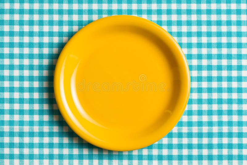 Opróżnia talerza na w kratkę tablecloth fotografia royalty free Opróżnia talerza na w kratkę tablecloth fotografia royalty free