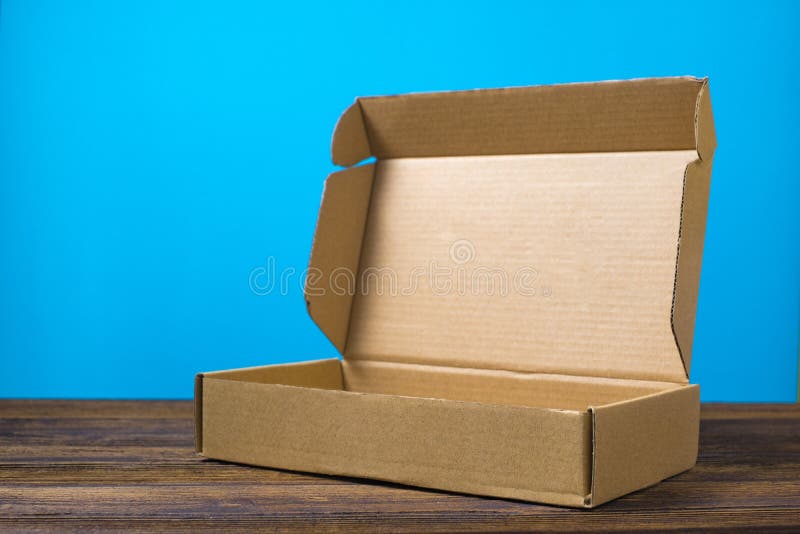 Opróżniam zamykał brown karton dla egzaminu próbnego up na ciemnym drewnianym tabl obraz stock Opróżniam zamykał brown karton dla egzaminu próbnego up na ciemnym drewnianym tabl obraz stock