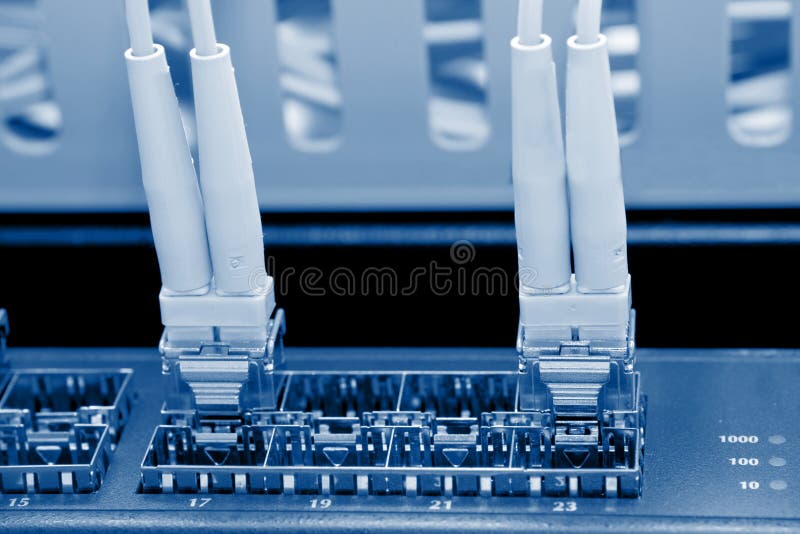 Optic fiber cables connected to a switch stock images Optic fiber cables connected to a switch stock images