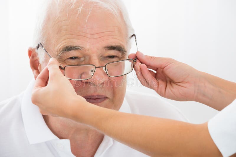 An Optician Helping Male Patient With New Eyeglasses stock images An Optician Helping Male Patient With New Eyeglasses stock images