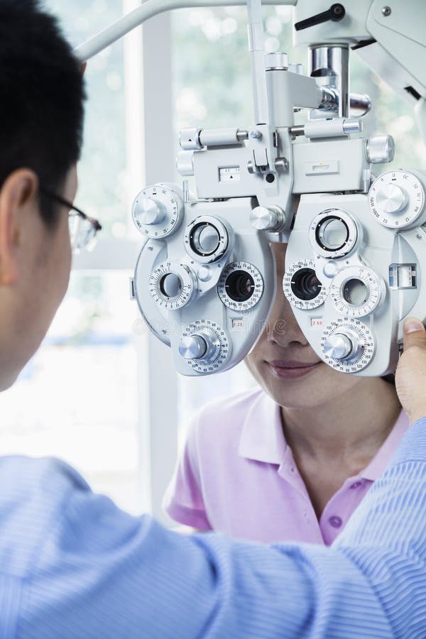 Optometrist robi oko egzaminowi na młodej kobiecie