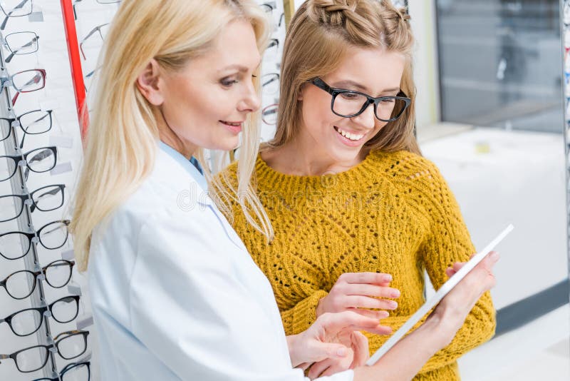 Optometrist с цифровым клиентом порции таблетки для того чтобы выбрать стекла стоковые фото