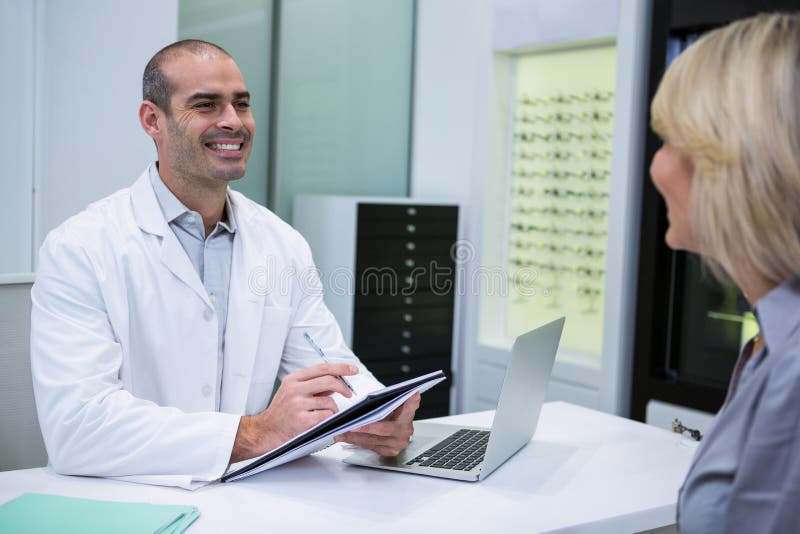 Optometrista maschio che parla con paziente femminile fotografie stock