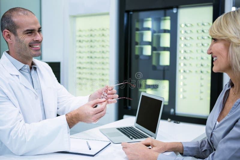 Optometrista maschio che parla con paziente femminile immagini stock