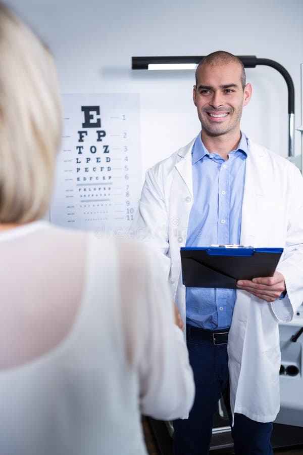 Optometrista maschio che parla con paziente femminile fotografie stock