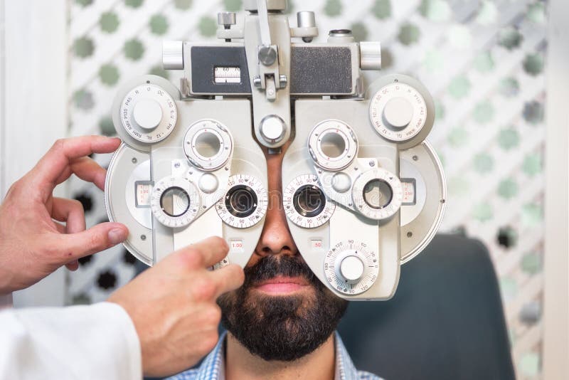 Optometrista que faz a vista que testa para o paciente masculino na clínica Oftalmologista masculino que examina o homem paciente fotografia de stock royalty free Optometrista que faz a vista que testa para o paciente masculino na clínica Oftalmologista masculino que examina o homem paciente fotografia de stock royalty free